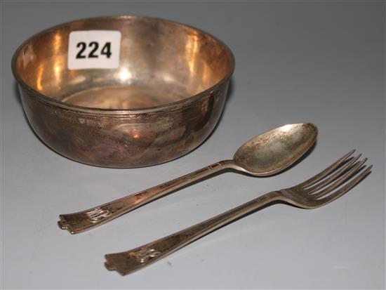 A silver christening bowl and silver spoon and fork
